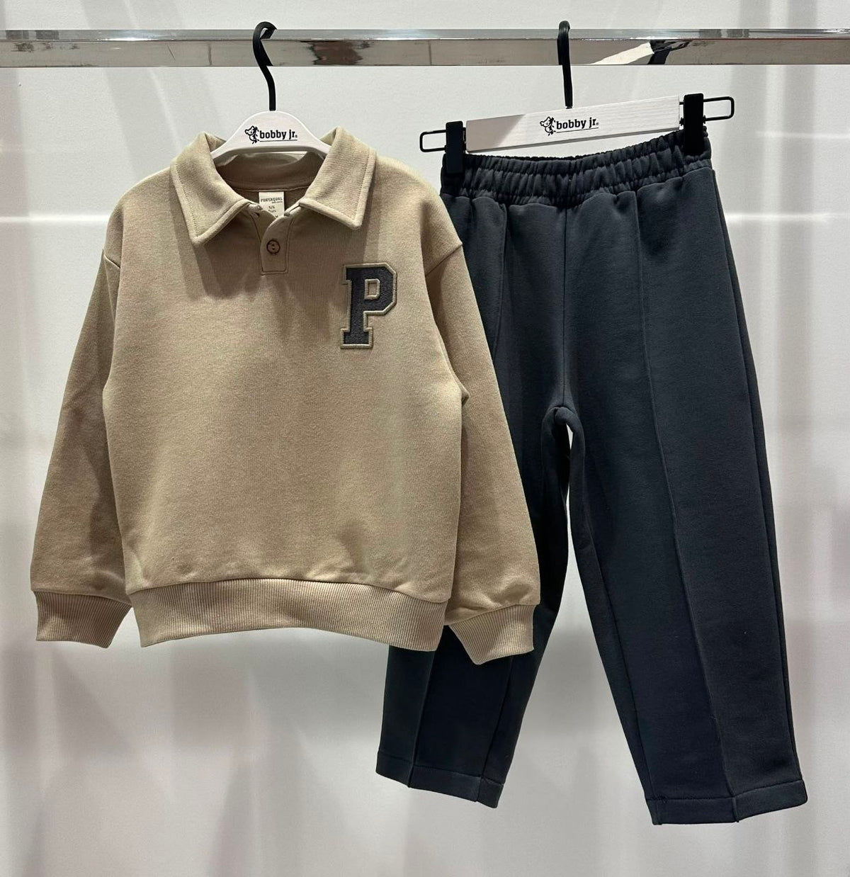 Beige collegetrui met "P"-patch en donkere broek